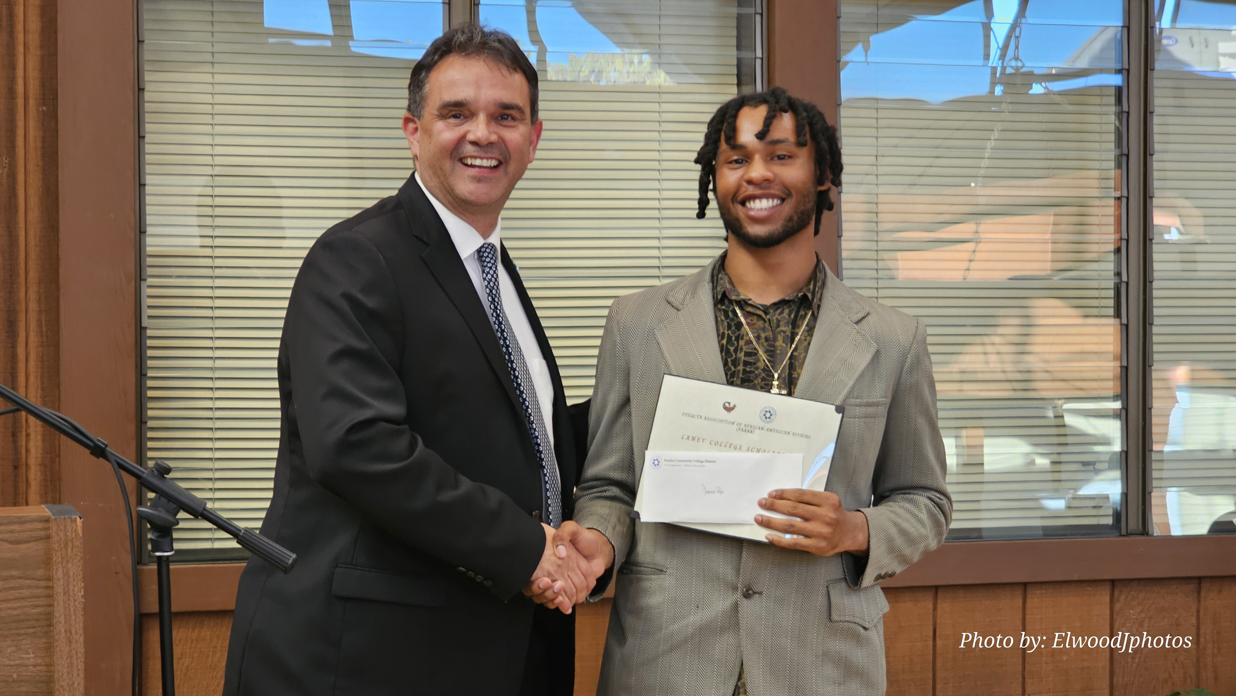 Laney College President Dr. Rudy Besikof presents a PAAAA Scholarship Award to Laney student Damien Pope, Jr.