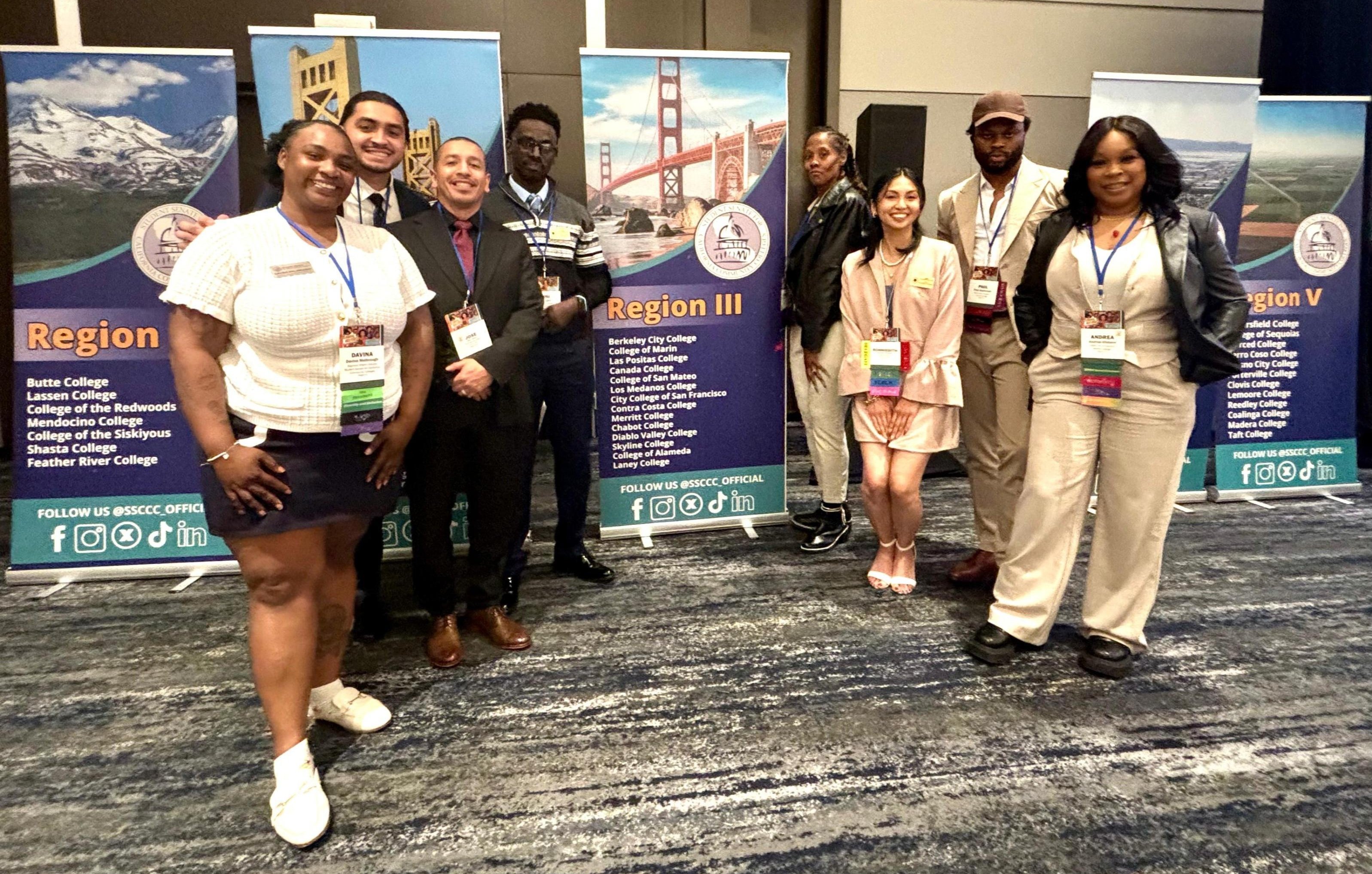 Eight people standing and smiling during the SSCCC conference in San Francisco in April 2026. On the left is Davina Malbrough from Merritt College.