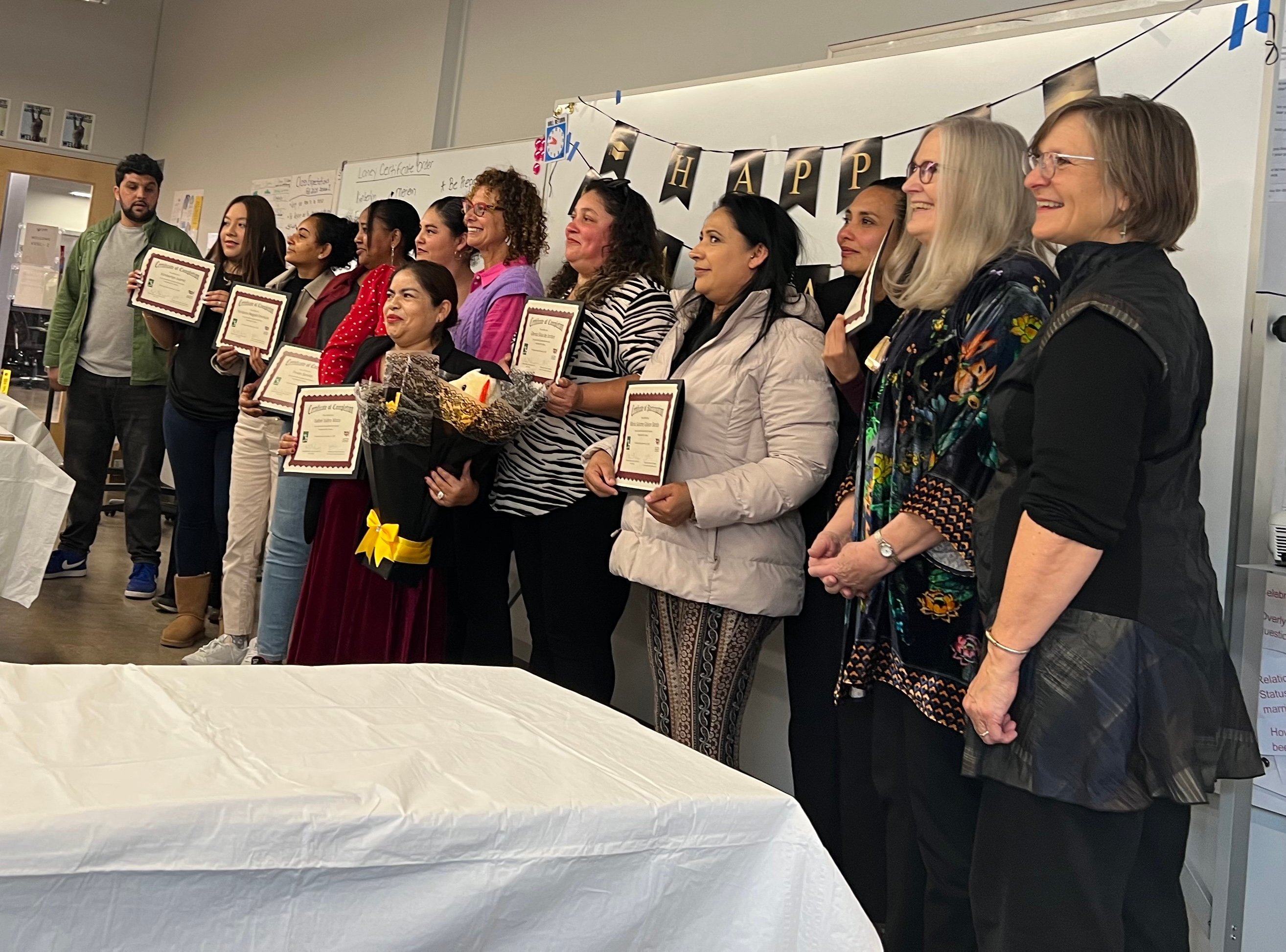 A group of happy students graduate from Laney College's Vocational English as a Second Language program in December 2025