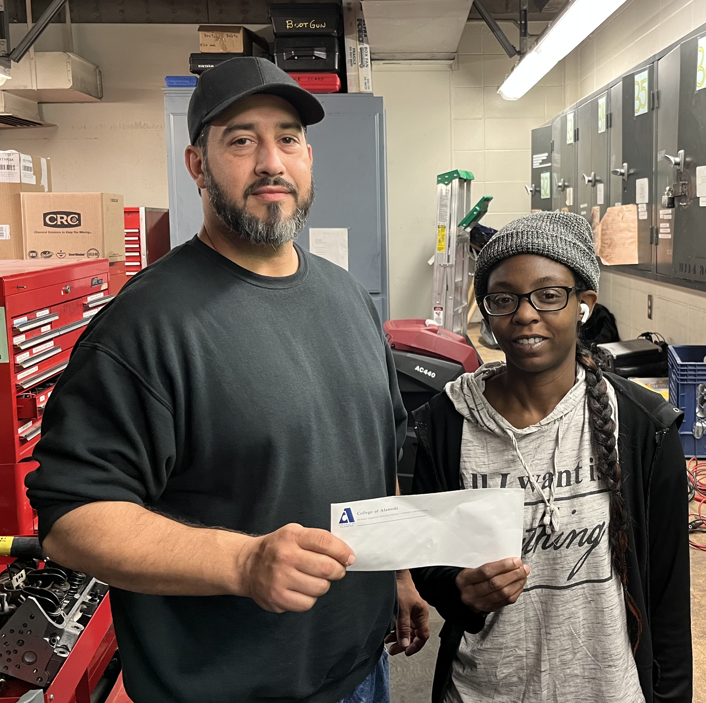 Yumeus (Missy) Taylor receives her Ozzie Day Scholarship check from Atech Toolroom keeper Candido Mejia 