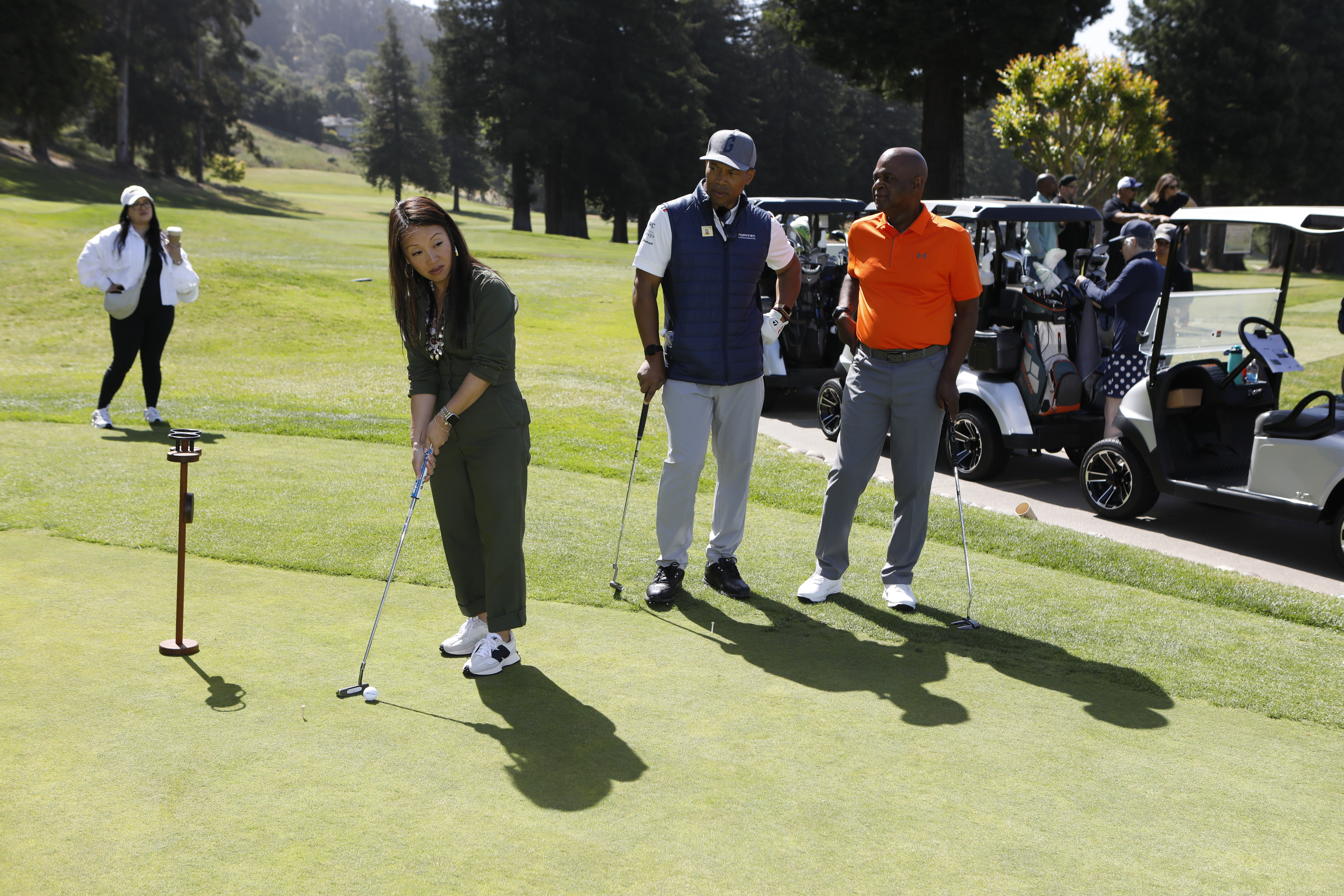 Peralta Chancellor Dr. Tammeil Gilkerson putting at the golf tournament
