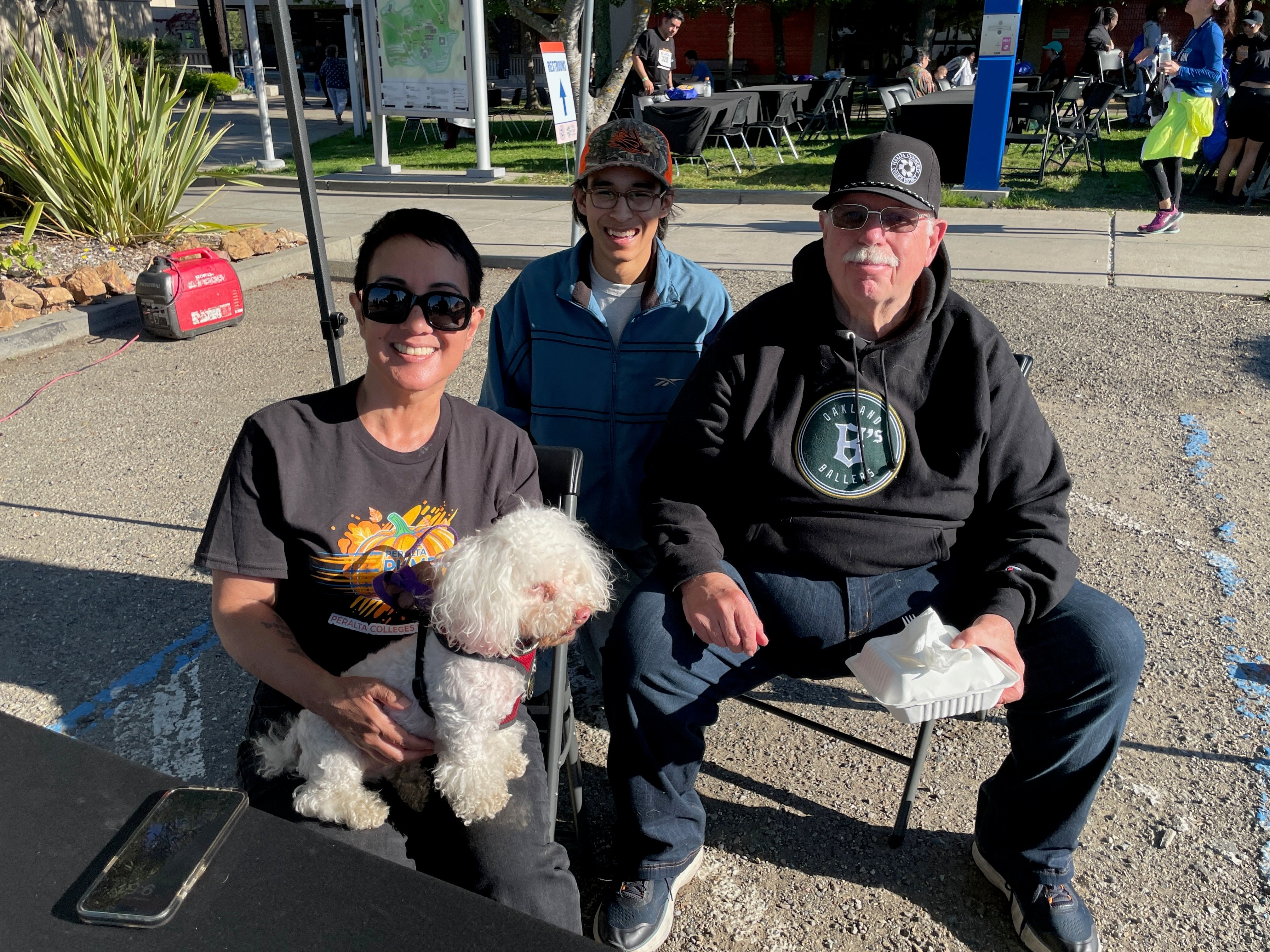 PCCD Trustee Paulina Gonzalez-Brito, Associated Students of Laney College President Owen Flaherty, and PCCD Board President Louis Quindlen rest up at the finish area