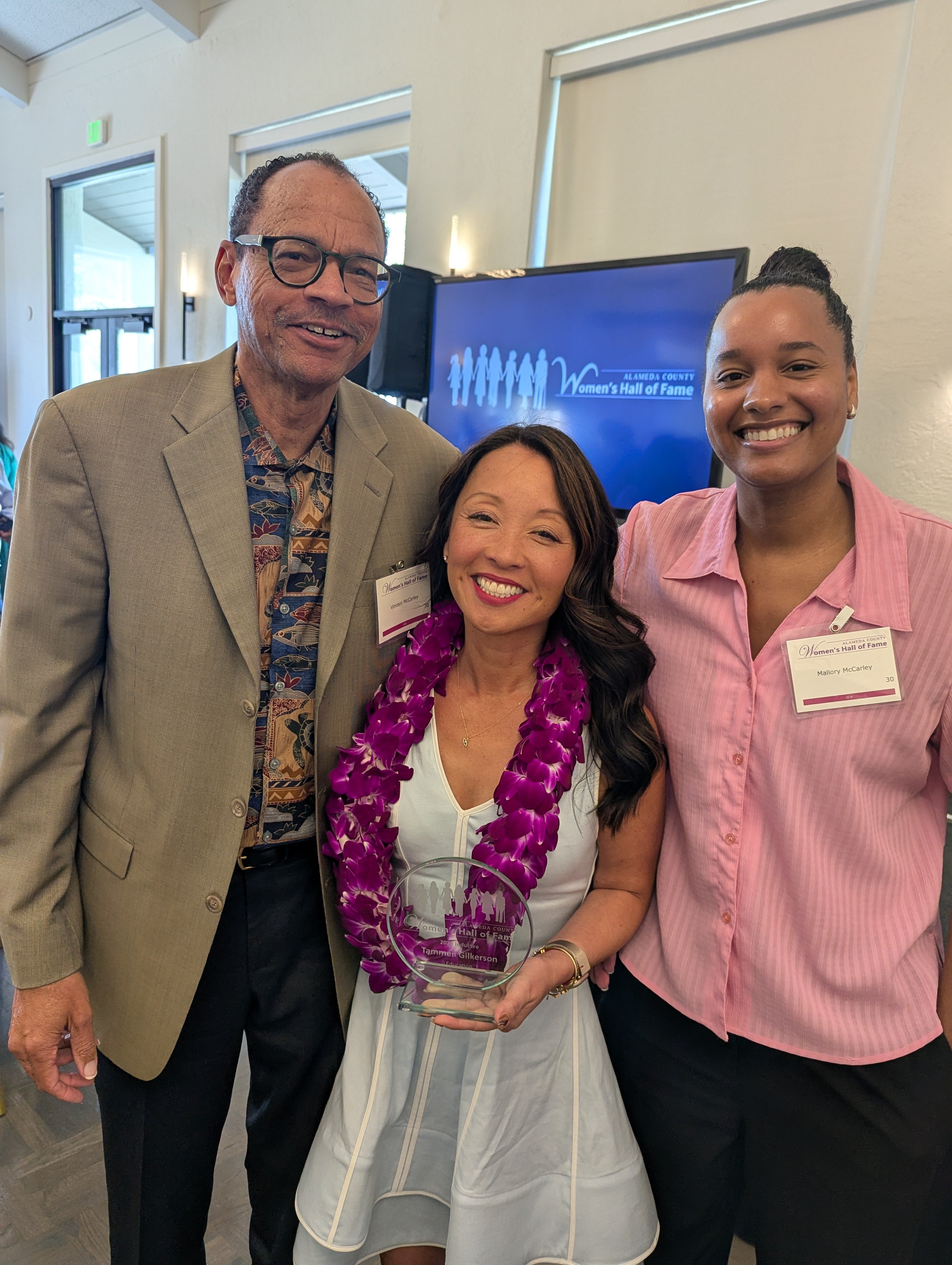 three people smiling, left to right: Vincent McCarley, Tammeil Gilkerson, and Mallory McCarley